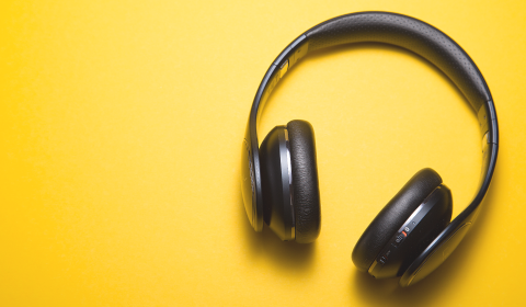audiobook banner with a pair of headphones on a yellow background