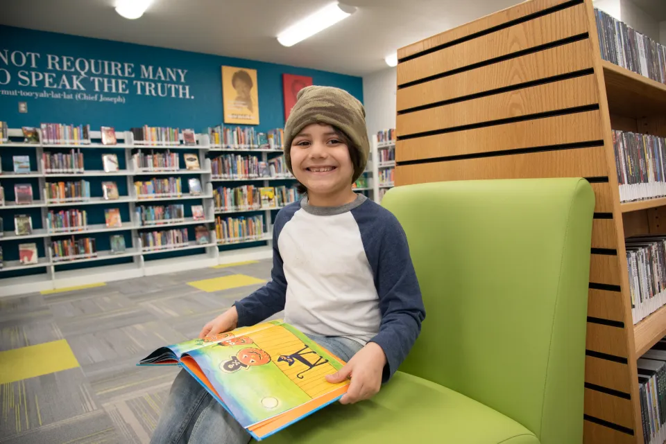 Child smiling while reading book