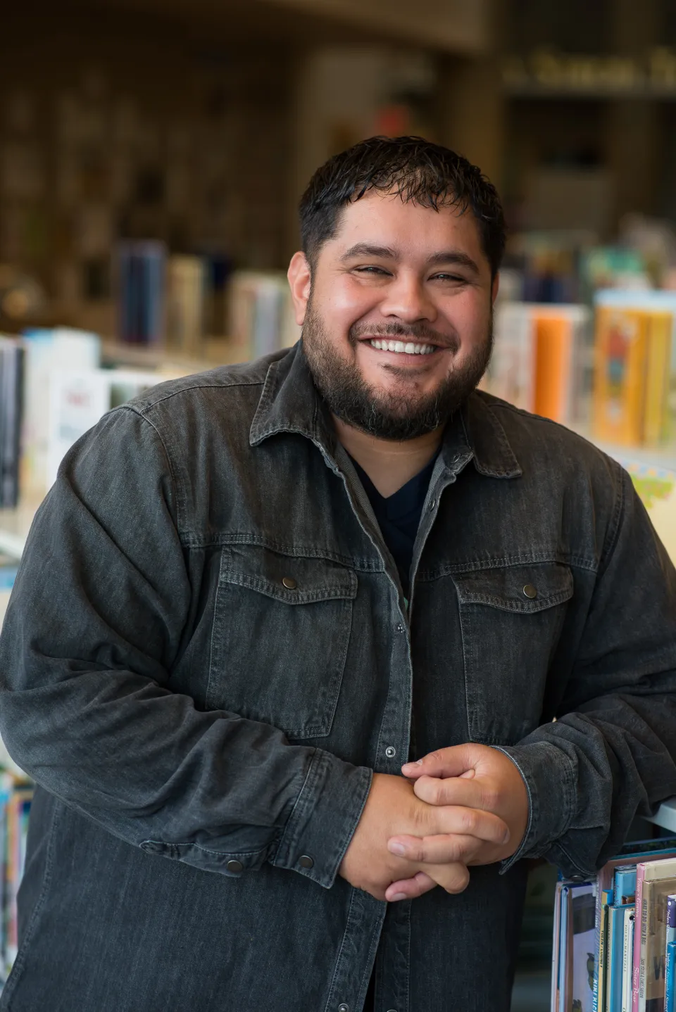 Photo of Carlo in front of books.